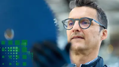 Person inspiziert ein Kreissägeblatt aus nächster Nähe, der Hintergrund ist verschwommen.