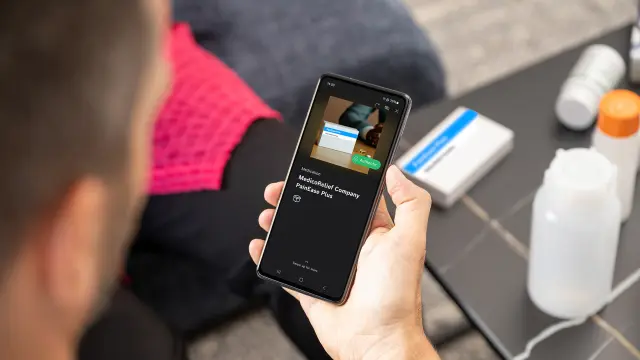 Smartphone showing an app verifying a medication package on a table.
