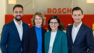Four people are standing in front of the Bosch logo, which can be seen in the background.