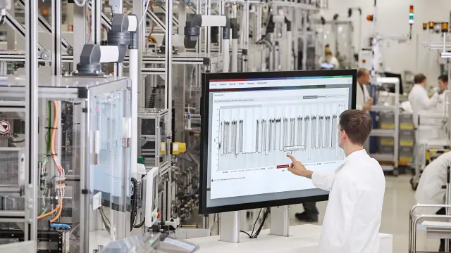 Der Bosch-Unternehmensbereich Industrial Technology. Ein Mitarbeiter arbeitet an einem großen Monitor und kontrolliert das Industrial Application System.