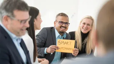 several people laugh together, one person holds a piece of paper with the text “Smart Automation”