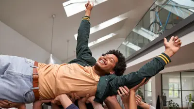 An associate is lifted up in the hands of the Bosch team and gets celebrated.