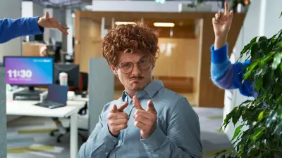Un equipo diverso de asociados posa divirtiéndose en una sala de reuniones llena de post-it. 