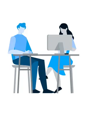 Ein Mann und eine Frau sitzen am Tisch vor einem Computer.