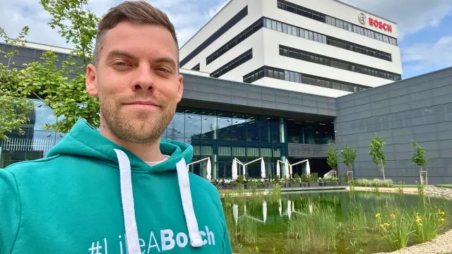 Tamás Boda steht vor einem Bosch Gebäude.