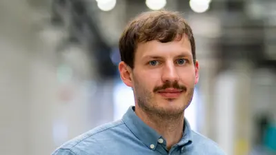Christoph Marx wears a blue shirt and smiles at the camera.