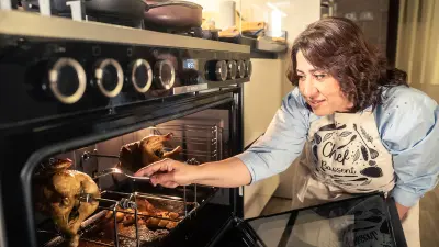 Frau bei der Zugereitung von Fleisch im Backofen