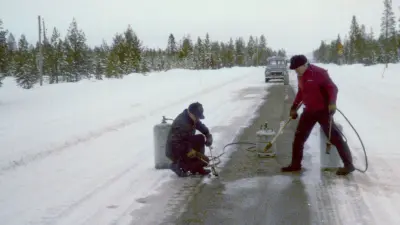 “Icemakers” Pelle Andersson (left) and David Sundström (right) prepare country road N95 near Arjeplog/Sweden for brake tests with and without antilock-braking system ABS, with right wheels on ice and left wheels on dry ground (ca. 1975).