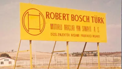 Yellow sign with Bosch lettering from the 1970s on a construction site
