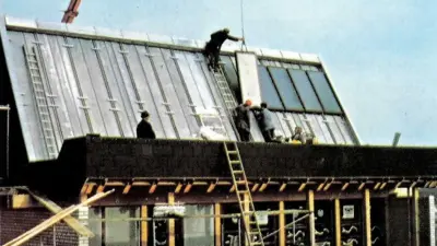 Auf dem Dach eines Hauses werden Sonnenkollektoren montiert