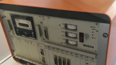 Box with the size of a suitcase, orange coating with many  switches on the front.