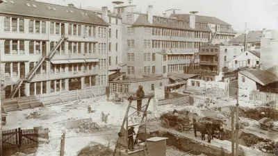 A view of a construction site in front of a row of buildings.