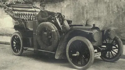 Chauffeur mit Mütze und Livree in einem Mercedes von 1907