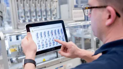 At the Bosch plant, an associate uses a tablet computer to analyze ongoing production.