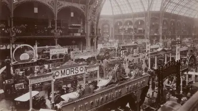 View into the exhibition hall with glass dome, with stands featuring vehicles from Peugeot, Fiat and many more.