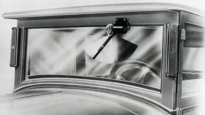 Black and white illustration, view of the front of a car, with the focus on a windshield with windshield wiper from 1926
