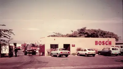Fabrikbau mit Bosch-Schriftzug und Autos davor