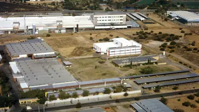 Luftbild auf einen Fabrikstandort, mit einigen Freiflächen dazwischen