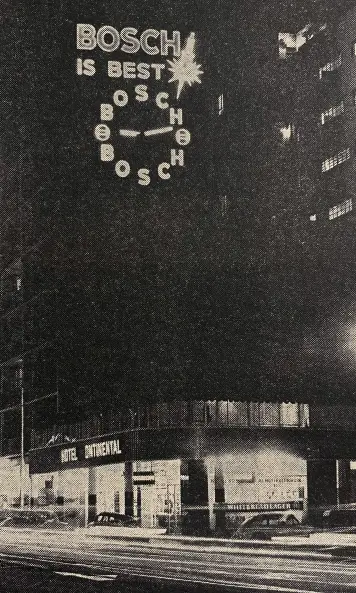 Nächtliche Straßenszene mit beleuchteter Uhr hoch an einem Gebäude