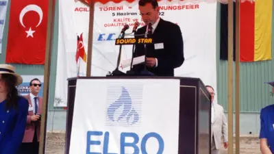 A man stands at a lectern and speaks into a microphone.