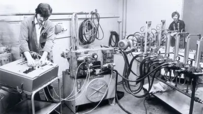 Zwei Männer in einem Prüfraum mit Testgeräten und Komponenten