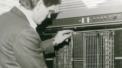 Ein Mann steckt eine geriffelte Elektronikplatte in einen Speicher.