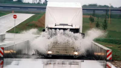 Ein Lkw fährt bergauf und durch die Wasserstrecke.