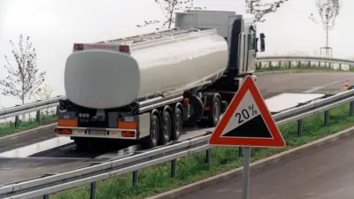 Ein Lkw fährt eine nasse, steile Straße hoch