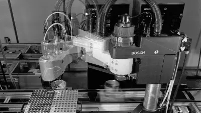 Schwenkarmroboter installiert an einer Montagelinie. Die Bewegung des Arms ist durch eine Mehrfachbelichtung eingefangen.