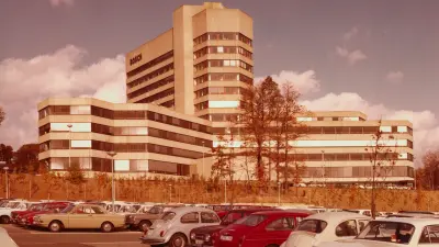 High-rise building with parking lot and cars in the foreground
