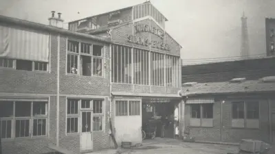 Der Eingang zur Fabrik um 1906; rechts im Hintergrund der Eiffelturm 