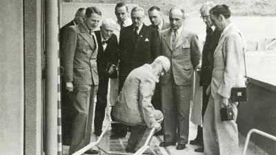 Among a group of men, Robert Bosch is testing a chair.