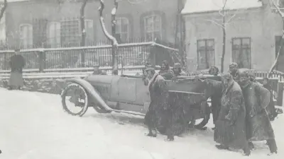 Bosch engineers on a winter test drive, pushing a car.