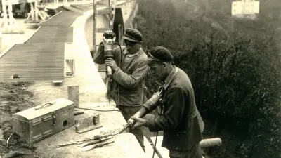 An einem steilen Hang arbeiten 2 Arbeiter mit dem Bosch-Hammer