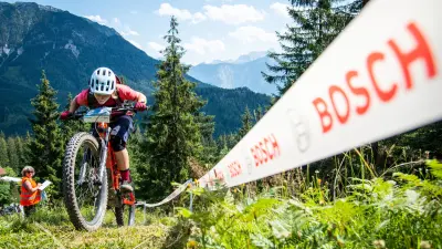 Mountain biker on a climb in the mountains and Bosch lettering on the right