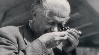 Bamminger checks a spark plug through a magnifying glass.