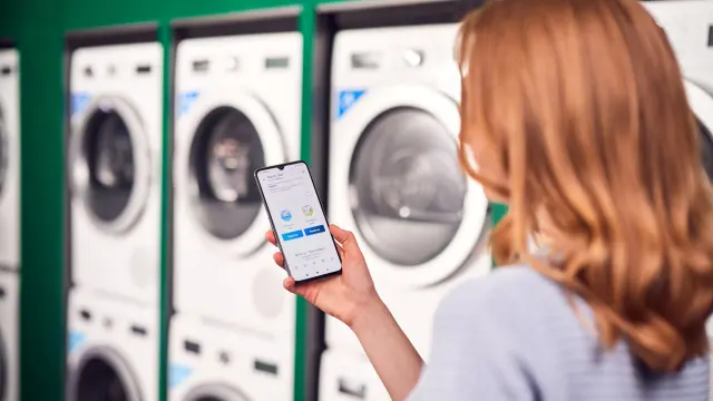 A woman looking on the WeWash app.