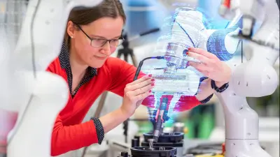 Female researcher in red shirt working with white robotic arm and holographic interface displays, demonstrating integration of perception and manipulation technologies in AI-driven robotics research.