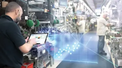 Industrial worker operating tablet interface with holographic display in automated manufacturing environment, representing AI-driven control systems and reinforcement learning applications in smart factory operations.