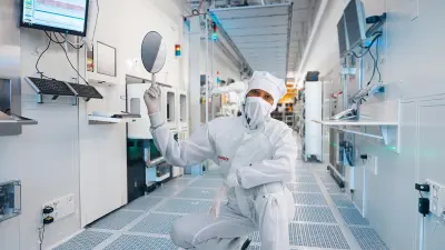 A Bosch associate shows a silicon wafer from which MEMS chips are produced.