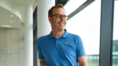 Research expert Ulli Hoffmann smiling at office window.
