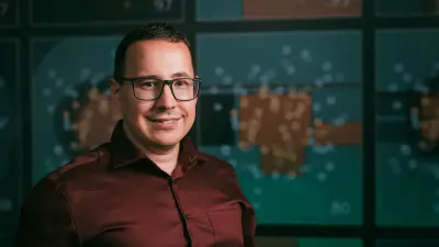 Damir Shakirov in dark red shirt smiling at the camera.