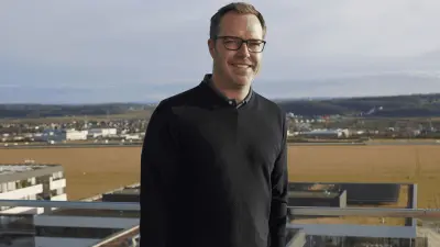Research expert Ulli Hoffmann stands smiling on balcony.