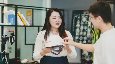 Eine Frau hält einen weißen Bosch Sicherheitshelm mit integriertem Elektroenzephalogramm (EEG) in der Hand. Ein Mann begutachtet den Helm.