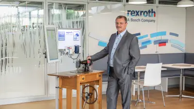 Pictured is Claus Lau, who has become known as the ’sewing machine man“ at Bosch and beyond. Next to him is the sewing machine from the 1930s that he has equipped with Industry 4.0 technology.