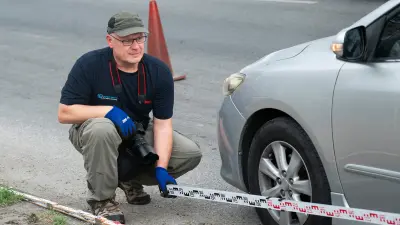 Bosch accident researcher Thomas Lich examines a crashed vehicle on a highway in Thailand