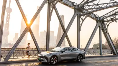 Car parked on a bridge with city skyline in the background at sunset