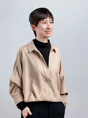 Person standing against a plain studio background