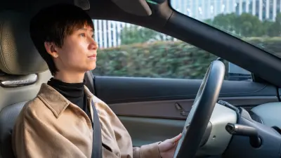 Interior view of a car with person seated at the steering wheel
