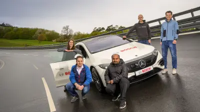 People from the project team standing next to a test vehicle.
